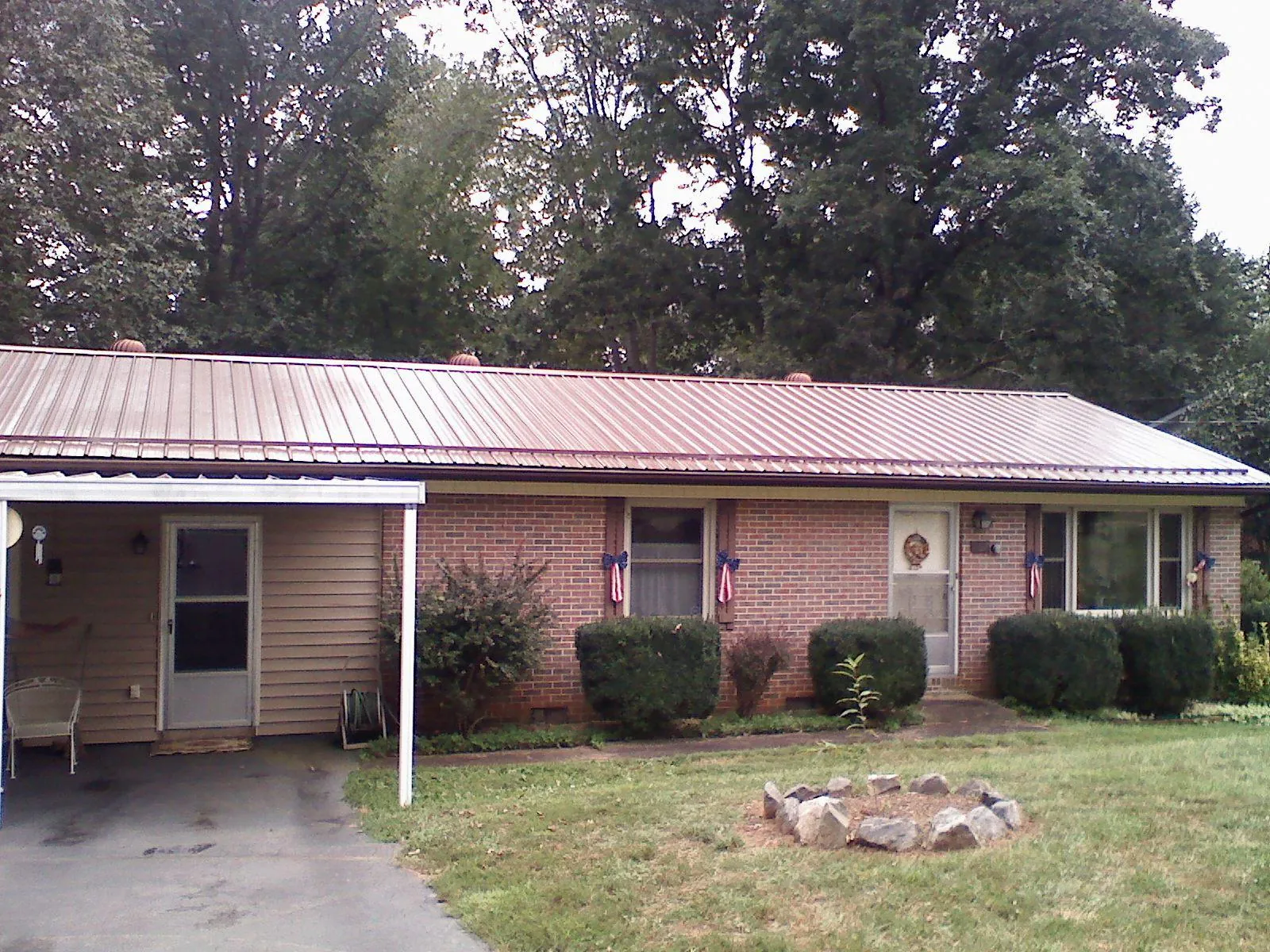 Bronze metal roof and carport on a brick ranch home — Roof Repair work by our crew in Cerro Gordo